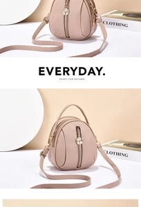 Detail of light pink lychee leather handbag with golden floral zipper and dual strap