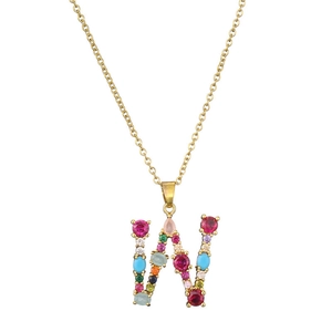 Detail of gold necklace featuring a large W pendant inlaid with colorful round gemstones