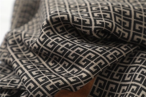 Close-up of soft black and beige geometric greek key pattern on cotton-linen scarf fabric