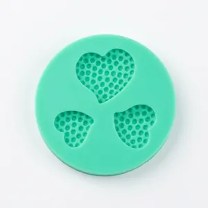 Top view of mint green silicone mold with three heart shapes for DIY resin or baking