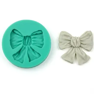 Detail showing the green silicone bow mold with a finished white resin butterfly casting