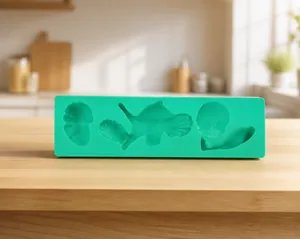Green silicone fondant mold featuring detailed teapot, strawberry, and leaf shaped cavities