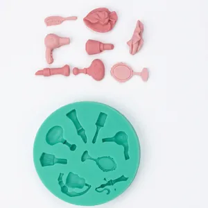 Detail of green silicone mold and pink fondant makeup tools like dryer and lipstick