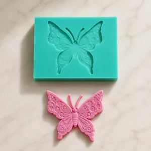 Detail of a butterfly-shaped silicone mold with a finished pink fondant cake topper
