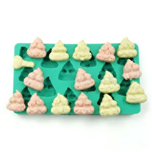 Detail of green silicone Christmas tree mold with fondant treats on a white background