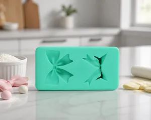 Close-up of green silicone mold with two different bow designs for cake decorating