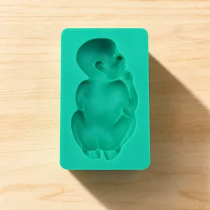 Detail of mint green silicone mold with a sleeping baby design for fondant and baking