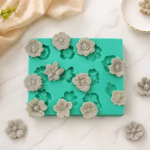 Macro detail of a green silicone mold with cherry blossom patterns and finished flower models