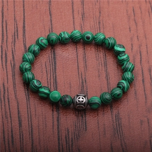 Detail of malachite texture green beads and vintage silver cross bead on bracelet