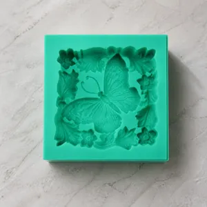 Detailed close-up of a square silicone mold featuring ornate butterfly and leaf patterns