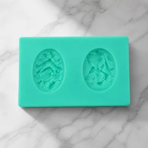 Detail of green silicone mold with two oval cavities featuring floral embossed patterns