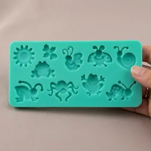 Macro view of green silicone fondant mold with sun and insect shapes for DIY cake baking