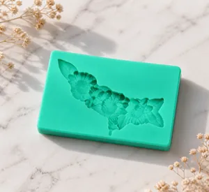 Macro detail of mint green silicone mold with intricate floral and leaf pattern for DIY cakes