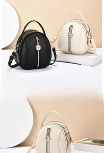 Close-up of textured faux leather mini bags featuring gold zippers and rose flower charms