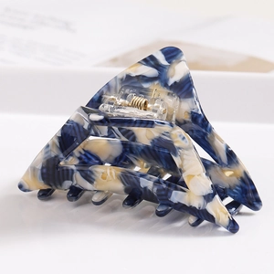 Macro detail of large triangular hair claw clip with blue and white marble pattern