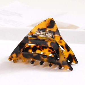Detailed macro view of a tortoiseshell acetate hair claw clip with geometric triangle design