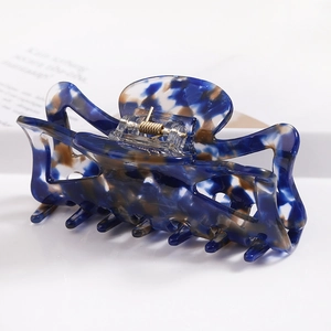 Detailed view of large acetate hair claw clip with blue and brown marble texture
