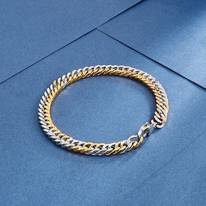 Macro shot of two-tone gold and silver Cuban chain link bracelet with lobster clasp