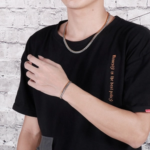 Close-up of men's two-tone silver and gold curb chain necklace and bracelet set