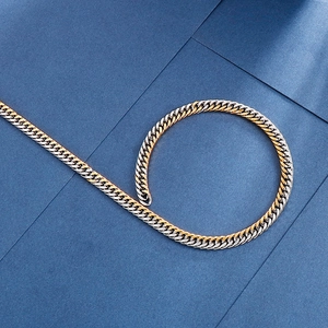 Close-up of gold and silver Cuban link chain with interlocking bicolor metal texture