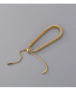 Close-up of golden woven titanium steel bracelet with adjustable slider clasp detail