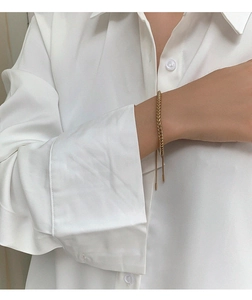 Close-up of golden woven wheat chain bracelet with adjustable slide buckle on wrist