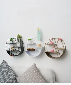 Close-up of three circular iron wall shelves in black, white and gold finishes