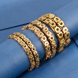 Macro view of golden Byzantine chains in various thicknesses on a blue background