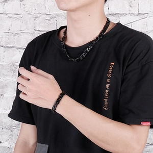Detail of hip-hop black flat Byzantine chain necklace and bracelet set on a male model