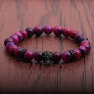 Makroaufnahme von 8mm lila Achatperlen mit schwarzem Totenkopf und Vintage-Metallteilen
