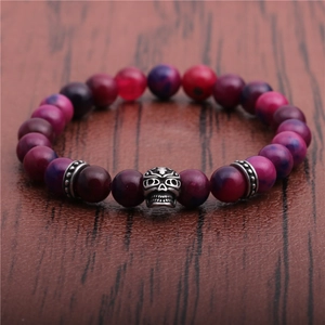 Makroaufnahme der 8mm lila Achatperlen und Vintage Silber Totenkopf-Charm auf Holzgrund