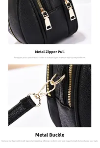 Detail of gold-plated zipper pulls and swivel snap hooks on black pebble leather bag
