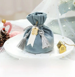 Detailed shot of Morandi blue velvet gift bag with silver tassels and golden metal charm
