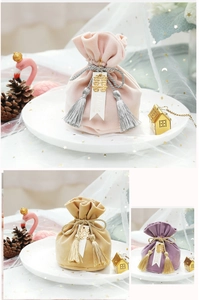 Close-up of velvet wedding favor bags with tassels, Sweet Love tags and golden charms