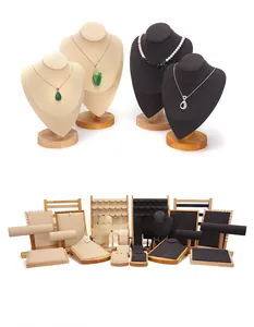Detail of wooden jewelry display set with beige microfiber neck busts and ring stands