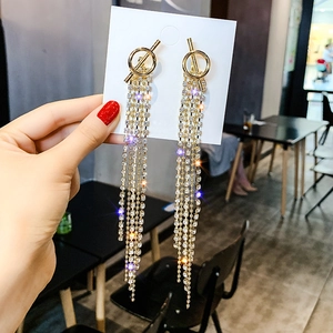 Detailed view of long gold tassel earrings with multiple rows of sparkling rhinestones