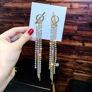Macro detail of long gold tassel earrings with rhinestone fringe and OT clasp design