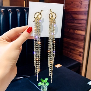 Detail of long gold tassel earrings with sparkling rhinestones and geometric design