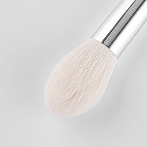 Flame-shaped highlighter brush with soft white bristles and shiny silver ferrule