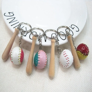 Detail of mini baseball bat keychains in four colors on a white ceramic plate