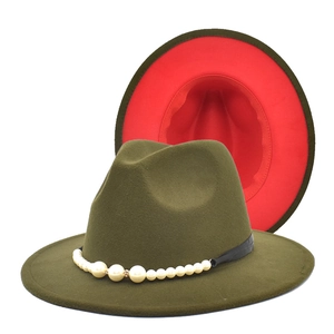 Détail d'un chapeau fedora en laine bicolore vert armée et rouge avec ruban perlé