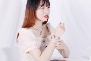 Close-up of silver heart pendant necklace and bracelet set with T-bar clasp on model