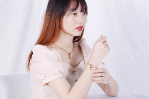 Close-up of a woman wearing gold heart pendant necklace and bracelet set in stainless steel