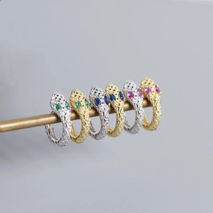 Close-up of S925 sterling silver snake earrings with colorful gemstone eyes in gold and silver