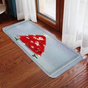 Close-up of a Christmas flannel floor mat with red tree design on dark wood flooring