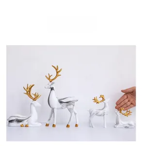 Detailansicht der weißen Keramik-Elchfiguren mit Marmormuster und goldenem Geweih-Akzent