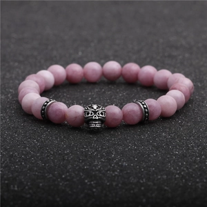 Macro shot of pink natural stone beaded bracelet with retro silver skull detail