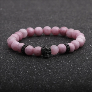 Close-up of 8mm purple natural stone beads with a black skull head charm on a bracelet