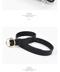 Detailed close-up of a black leather belt featuring a textured golden circular buckle