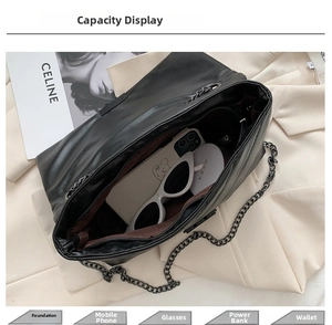 Internal view of the black chain bag showing capacity for phone, sunglasses, and makeup